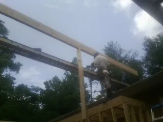 Carpenter setting a ridge beam over a new addition frame — Ice Dam Removal by Roofing Brothers in Watchung