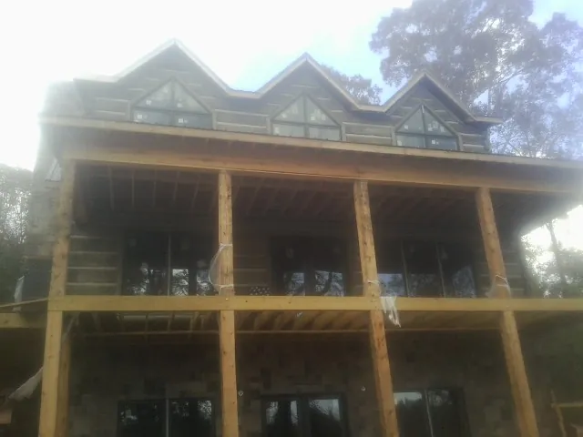 Dormers and porch framing on a large log home under construction — Roof Coating work by our crew in Watchung