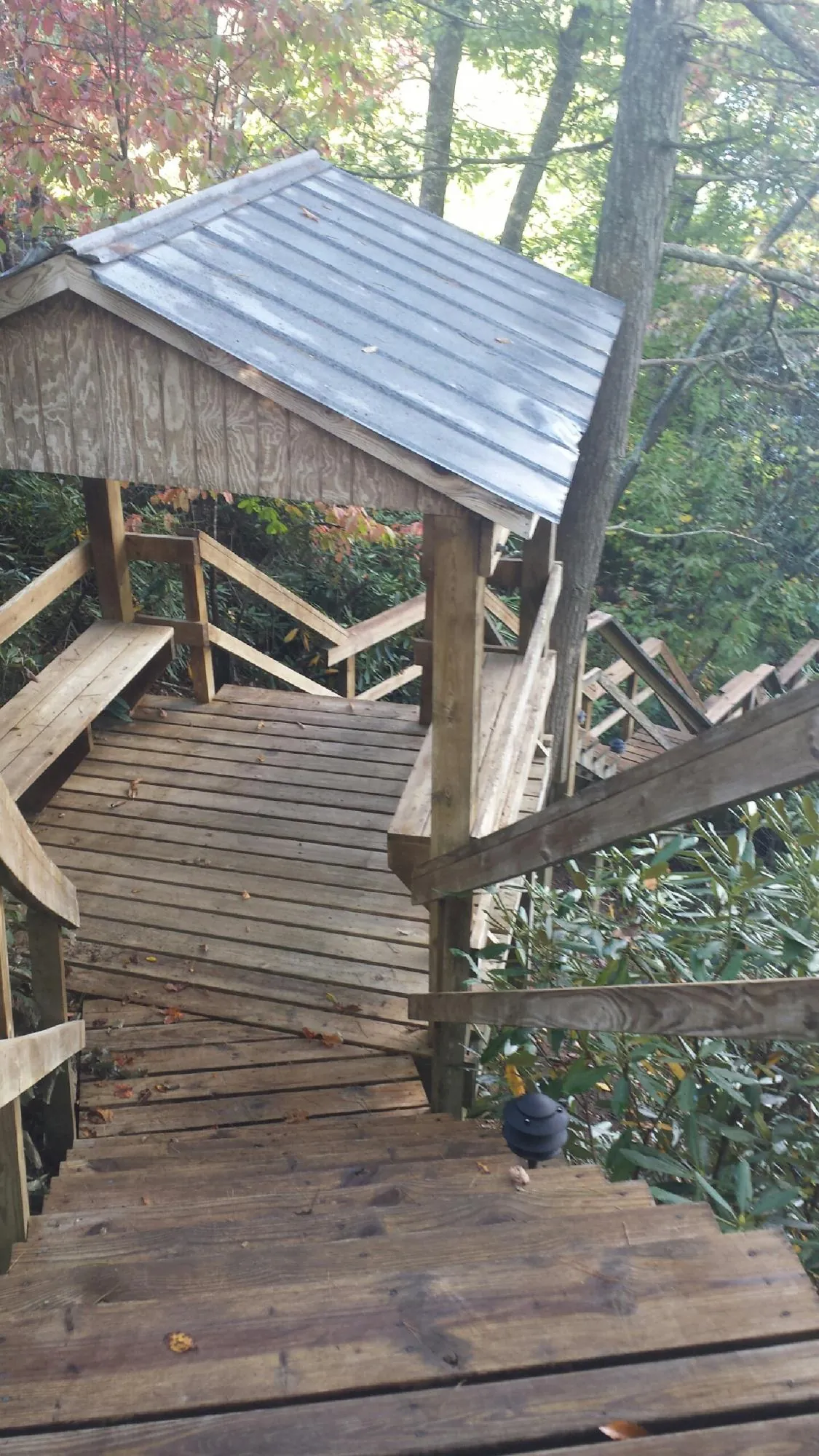 Metal roofed shelter over wooden steps on a wooded walkway — Skylight Repair & Installation work by our crew in Watchung